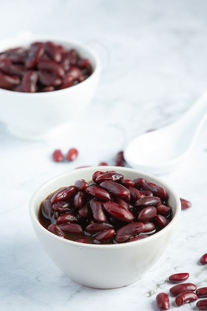 Haricot rouge bouilli dans un bol blanc place sur un sol en marbre blanc