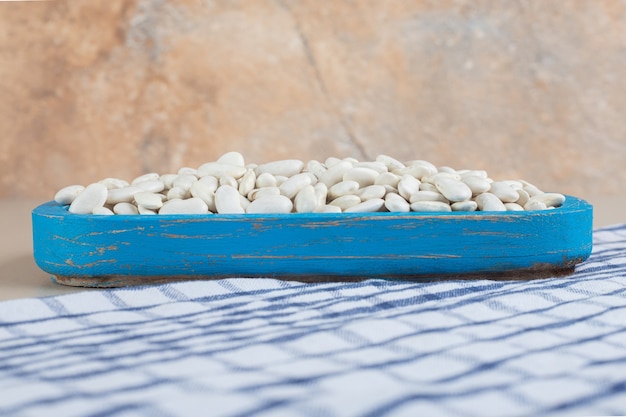 Haricots blancs sur un plateau sur du béton.