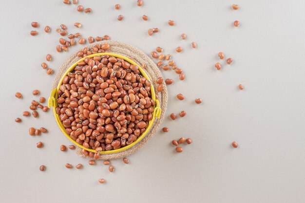 Haricots bruns dans une assiette en céramique sur béton.