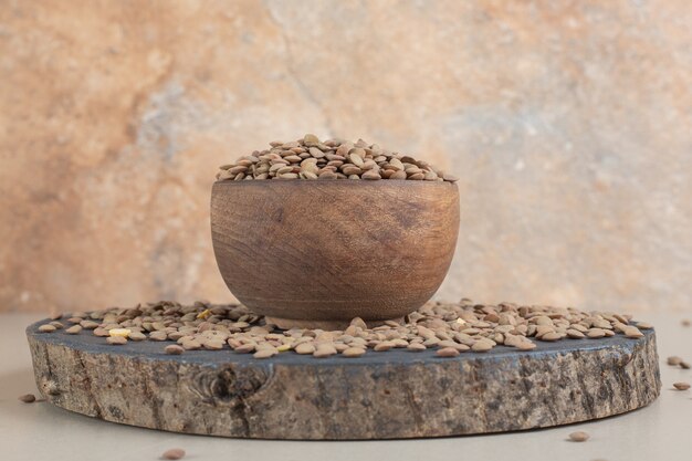 Haricots de lentilles vertes sur un plateau en bois.