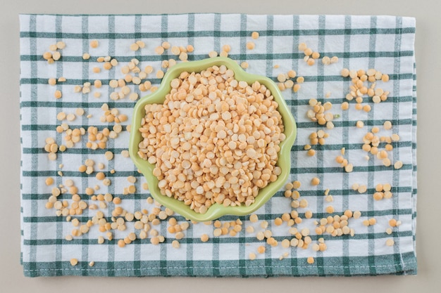 Haricots de pois jaunes dans une tasse en céramique sur du béton.