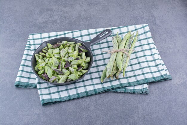 Haricots verts hachés dans une casserole sur une surface bleue