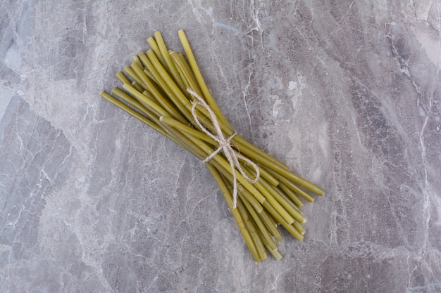 Photo gratuite haricots verts marinés attachés avec une corde.