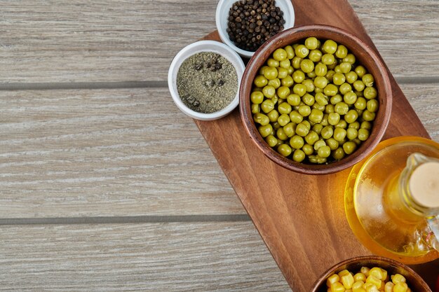 Haricots verts marinés avec maïs dans des coupes en bois.