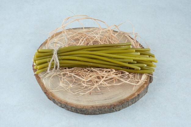 Photo gratuite haricots verts marinés sur morceau de bois.