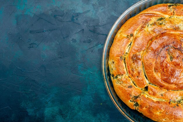 Haut de la page fermer la pâtisserie verdoyante avec des verts à l'intérieur sur fond sombre.