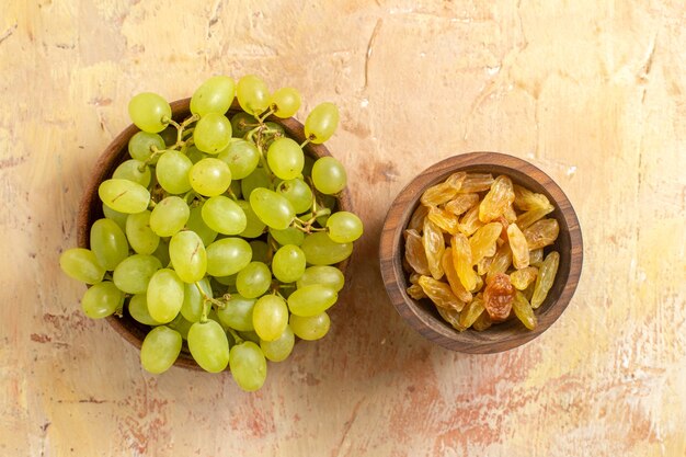 Haut de la page vue rapprochée des bols de raisins de raisins verts et de raisins secs sur la table