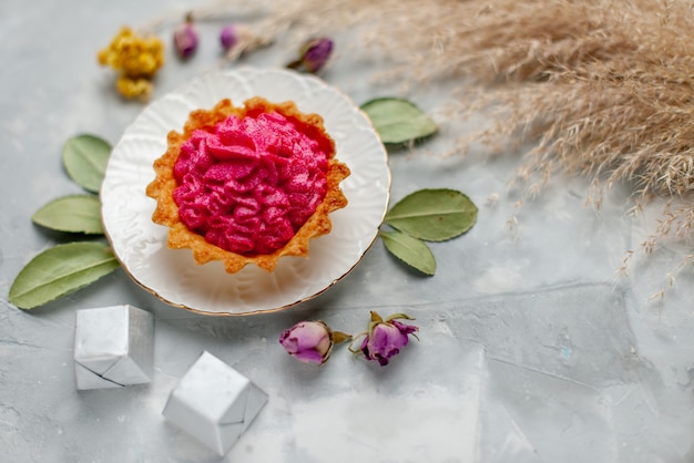 Haut de la page vue rapprochée de délicieux petit gâteau à la crème rose et petits chocolats sur la lumière, gâteau sucré au four crème bonbons au thé