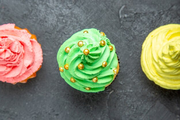 Haut de la page vue rapprochée mini cupcakes colorés sur fond sombre