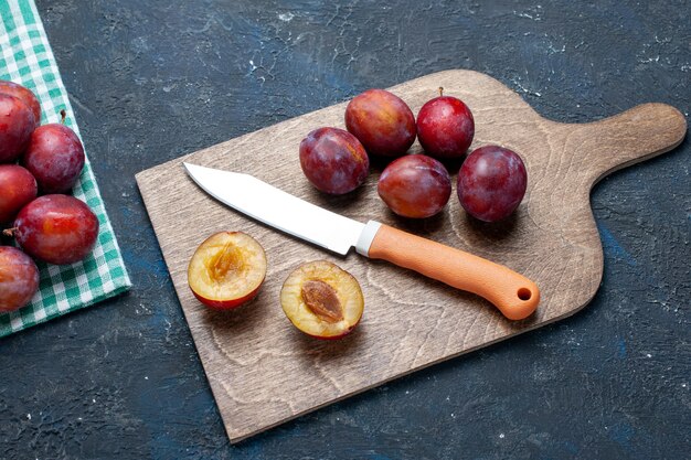 Haut de la page vue rapprochée de prunes fraîches entières moelleuses et juteuses sur sombre, fruits frais couleur vitamine été