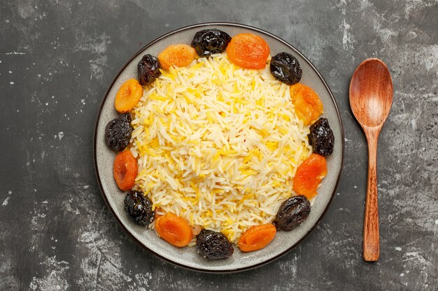 Haut de la page vue rapprochée de riz cuillère les fruits secs appétissants et le riz dans l'assiette sur la table