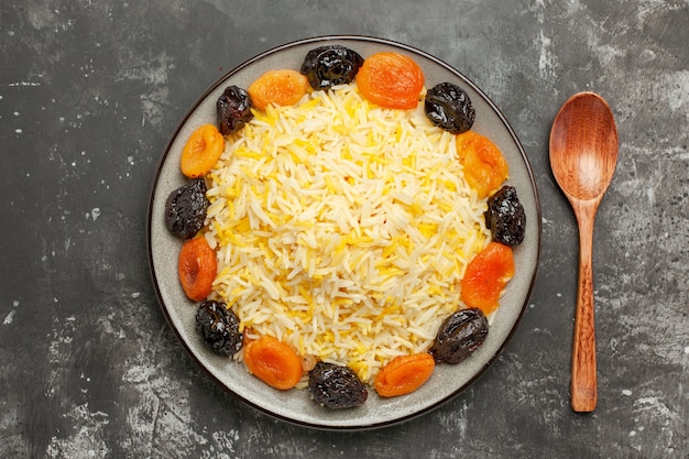 Haut de la page vue rapprochée de riz cuillère les fruits secs appétissants et le riz dans l'assiette sur la table