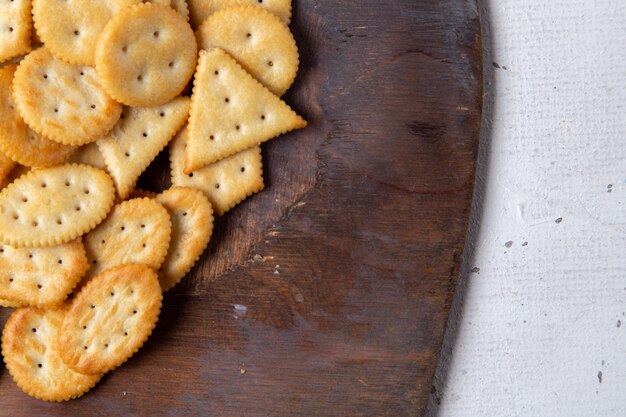 Haut de la page vue rapprochée savoureuses chips salées sur le bureau en bois et fond clair collation craquelin croustillant