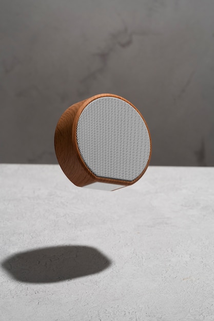 Photo gratuite haut-parleur sans fil rond moderne avec un design élégant flottant sur fond de béton