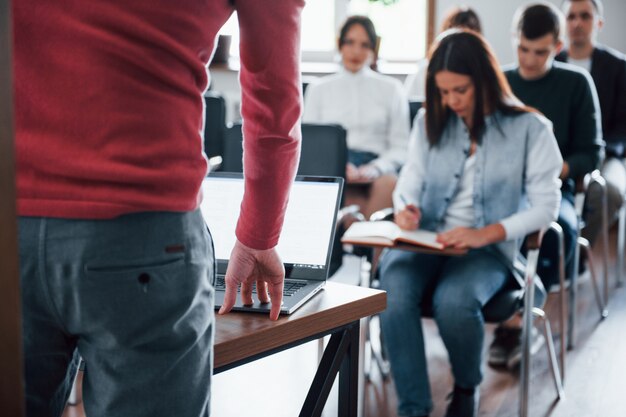 Le haut-parleur utilise un ordinateur portable. Groupe de personnes lors d'une conférence d'affaires dans une salle de classe moderne pendant la journée