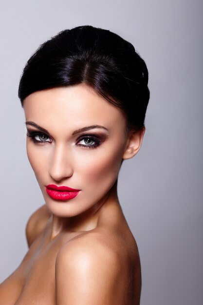 Haute couture look.glamour closeup portrait de belle sexy caucasienne jeune femme modèle avec des lèvres rouges, maquillage lumineux, avec une peau parfaitement propre isolée sur fond gris