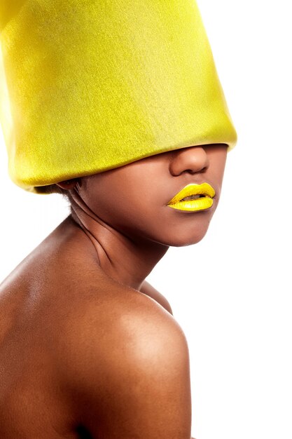 Haute couture look.glamour fashion belle femme américaine noire avec des lèvres lumineuses jaunes avec un matériau jaune sur la tête isolé sur blanc