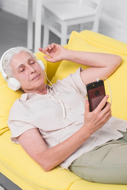 Haute femme écoute de la musique sur le casque dormir