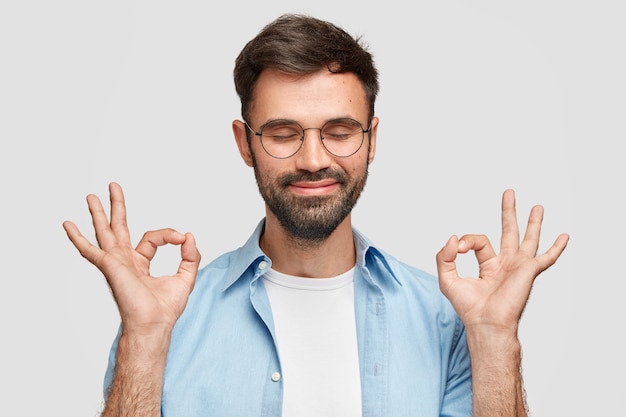 Hé, j'ai ot! Heureux homme satisfait avec une barbe épaisse, dit que tout va bien et sous contrôle avec un geste