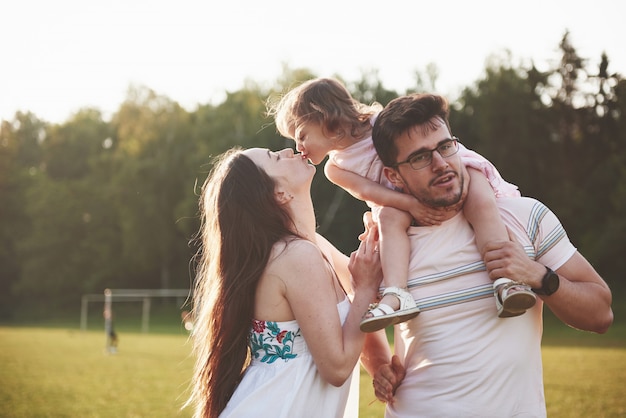 Héhé, père de mère et fille de bébé dans la nature au coucher du soleil