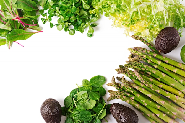 Herbes vertes, asperges et avocat noir sur fond blanc. Vue de dessus. Mise à plat