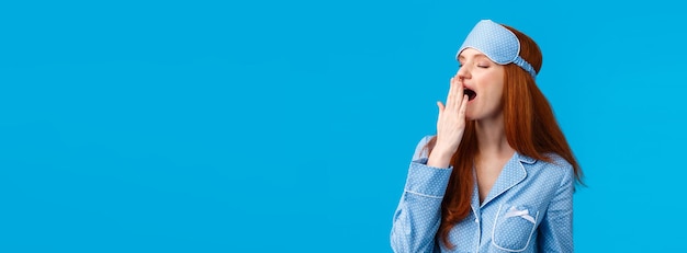 L'heure du coucher somnolente et fatiguée femme rousse féminine sensuelle mignonne en vêtements de nuit porter un pyjama et dormir