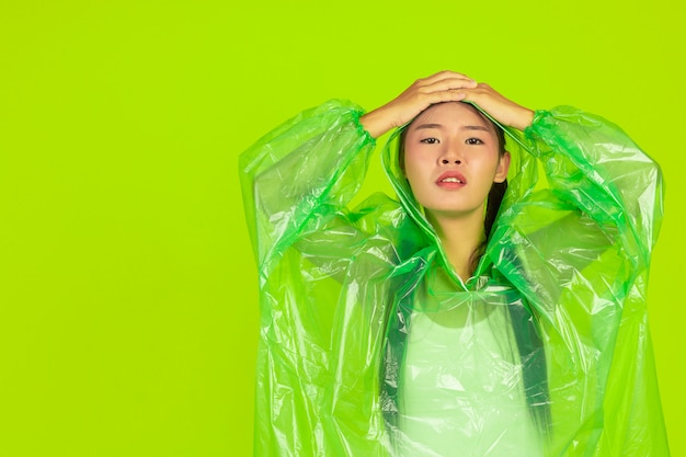 heureuse belle fille, portant des vêtements verts, un parapluie et un manteau, jour de pluie.