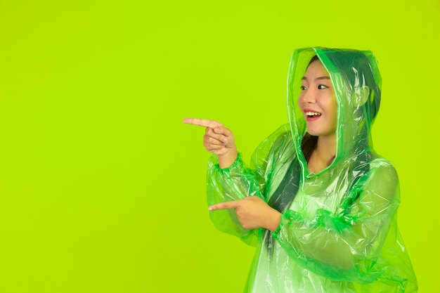 heureuse belle fille, portant des vêtements verts, un parapluie et un manteau, jour de pluie.