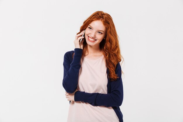 Heureuse belle jeune femme rousse parler par téléphone mobile.