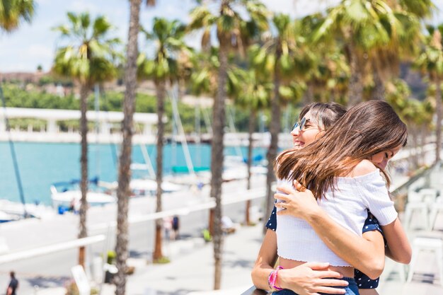 Photo gratuite heureuse copines étreindre sur le front de mer