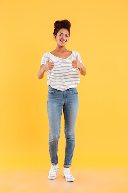 Heureuse dame aux cheveux bouclés montrant les pouces vers le haut isolé