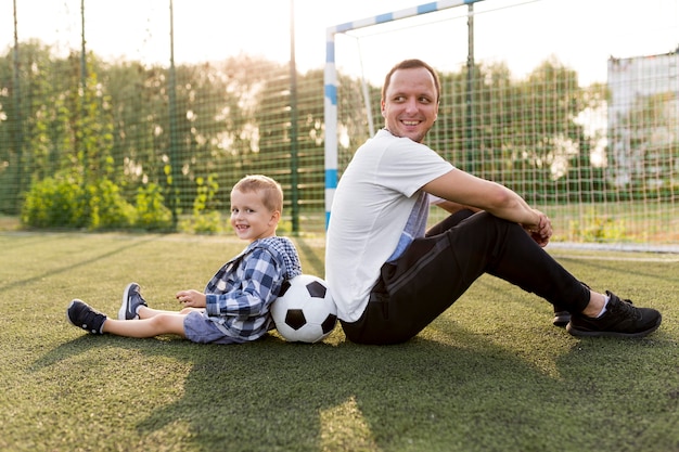 Photo gratuite heureuse famille monoparentale assise sur l'herbe