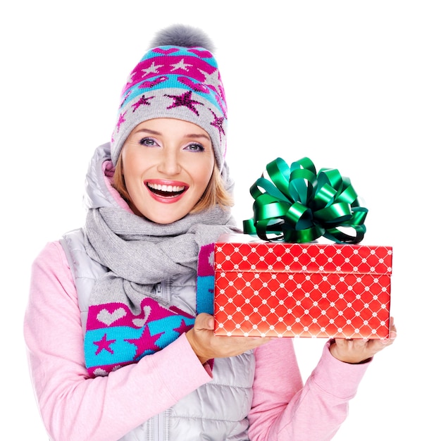 Heureuse femme adulte avec un cadeau dans un vêtement d'hiver isolé sur blanc