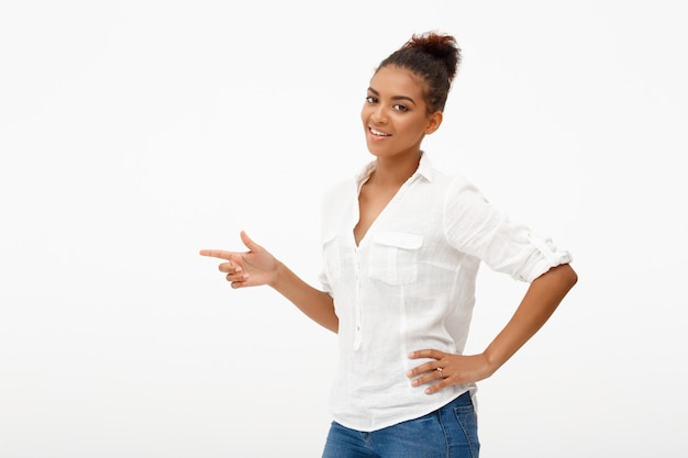 Heureuse femme afro-américaine pointant vers la gauche