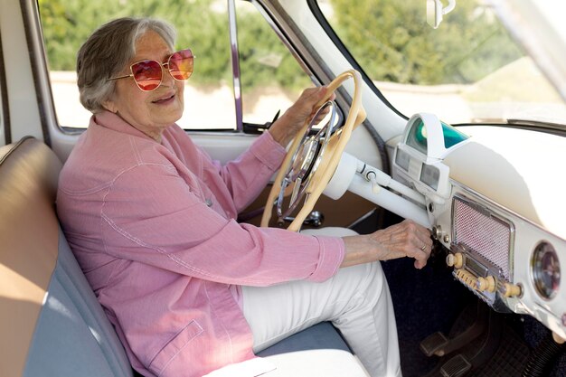 Heureuse femme âgée voyageant seule en voiture