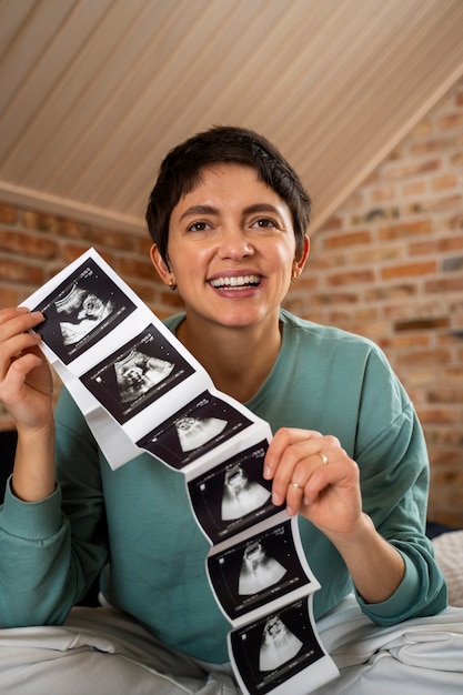 Heureuse femme annonçant une grossesse avec échographie