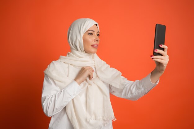 Heureuse femme arabe en hijab. Portrait de jeune fille souriante, posant au fond de studio