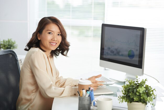 Heureuse femme asiatique au bureau