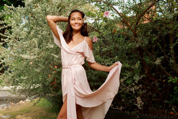 Heureuse femme asiatique gracieuse marchant dans le parc en journée ensoleillée d'été.