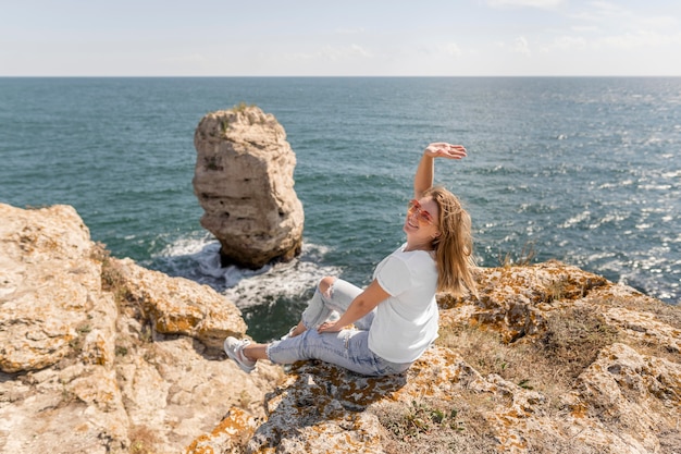 Heureuse femme assise sur des rochers