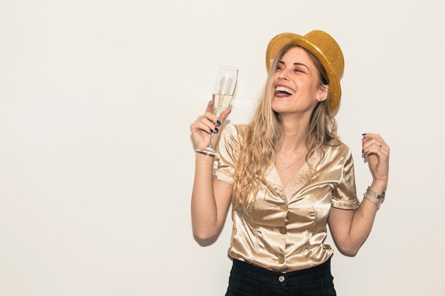 Heureuse femme au chapeau avec verre de champagne