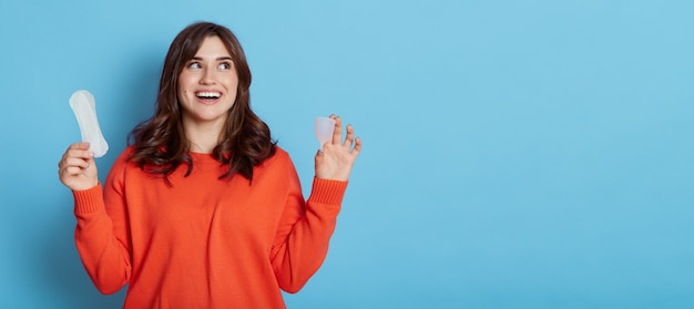 Heureuse femme aux cheveux noirs excitée à la recherche de suite avec un sourire à pleines dents