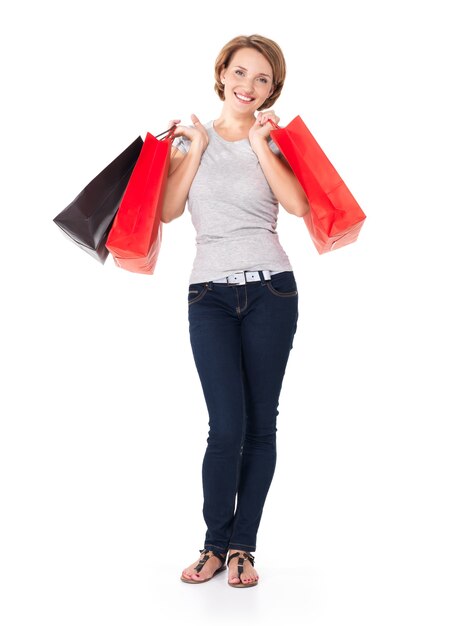 Heureuse femme blanche avec des sacs à provisions sur blanc