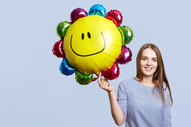 Heureuse femme brune porte un chemisier à rayures