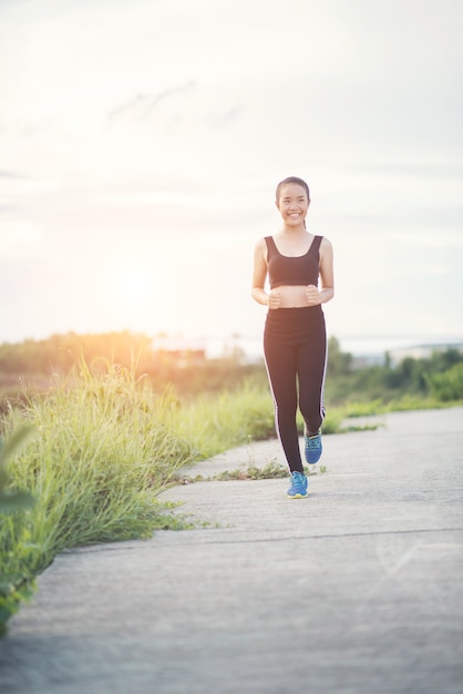 Heureuse femme coureur s&#39;exécute dans l&#39;exercice de jogging du parc.