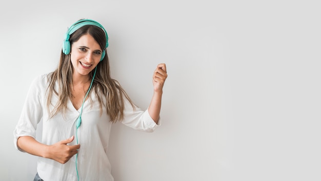 Heureuse femme dansant avec des écouteurs