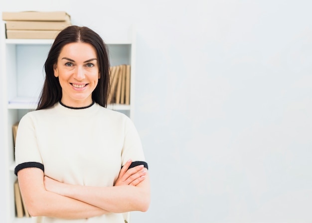 Photo gratuite heureuse femme debout avec les bras croisés