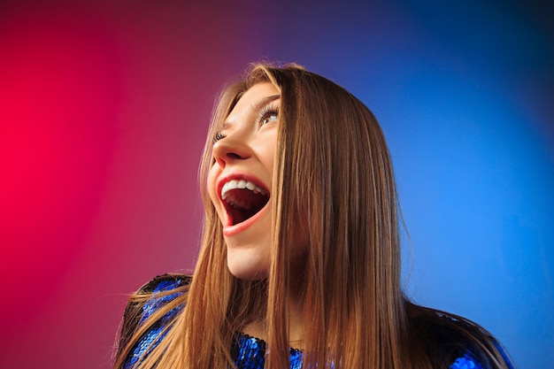 Heureuse femme debout, souriant sur studio coloré.