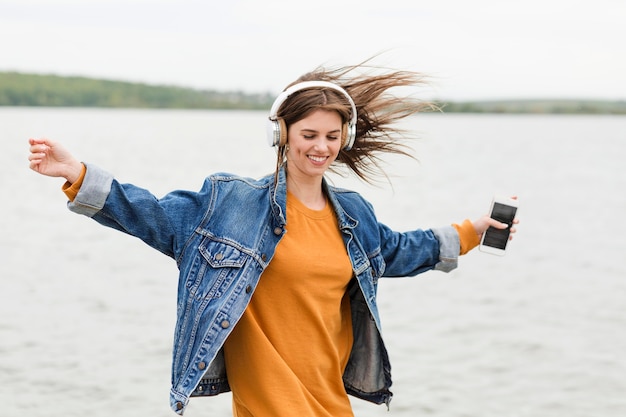 Photo gratuite heureuse femme écoutant de la musique dans la nature