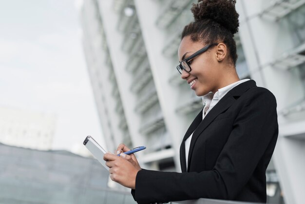 Heureuse femme écrivant dans le bloc-notes